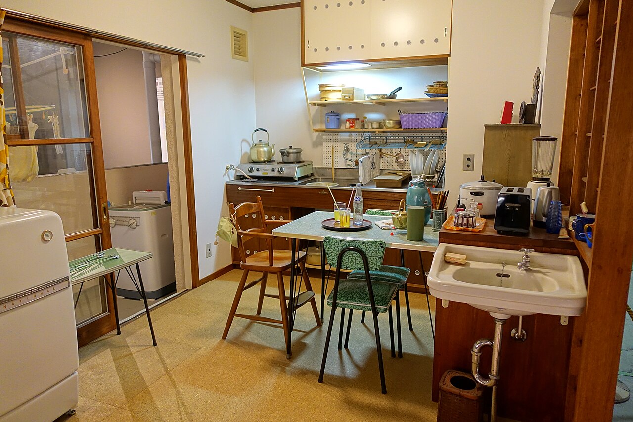 A full-size reproduction of a 1962 danchi kitchen with a National refrigerator, twin-tub washer, and a small formica dining table.