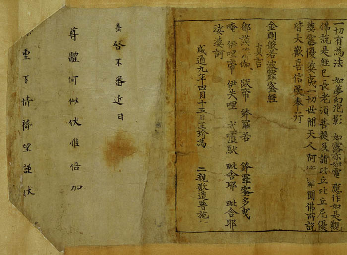 The end of a Chinese scroll: a framed panel of brush-and-block characters on yellowed paper, with a joined blank sheet to the left.