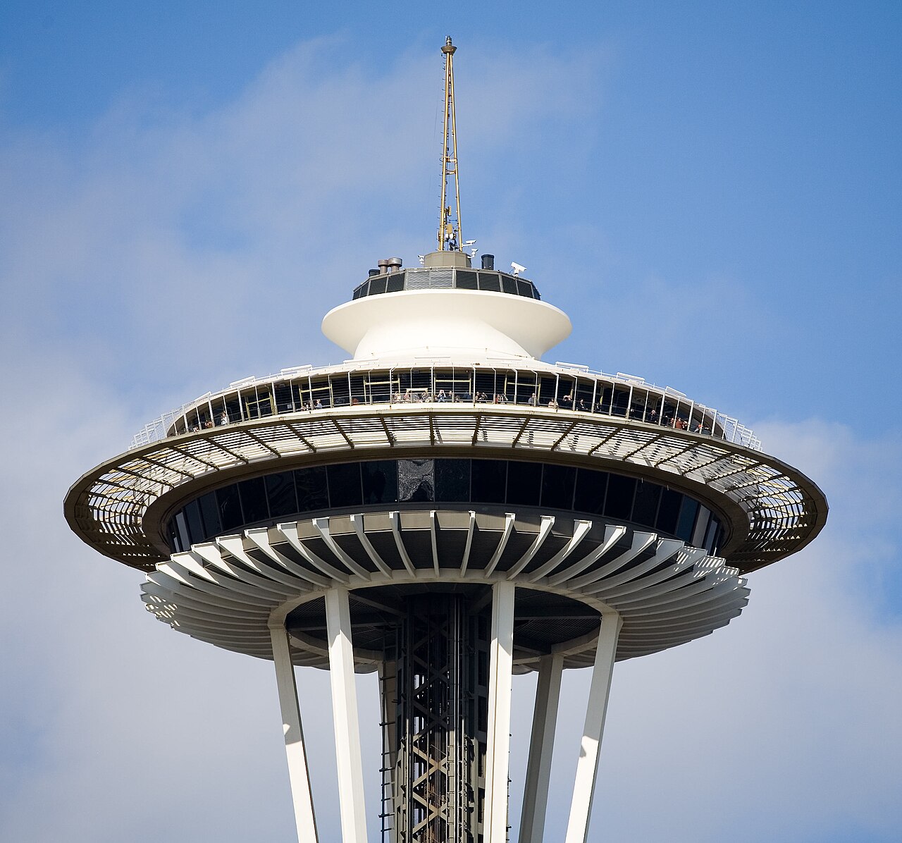 The saucer-shaped observation deck of the Space Needle in Seattle against a blue sky.