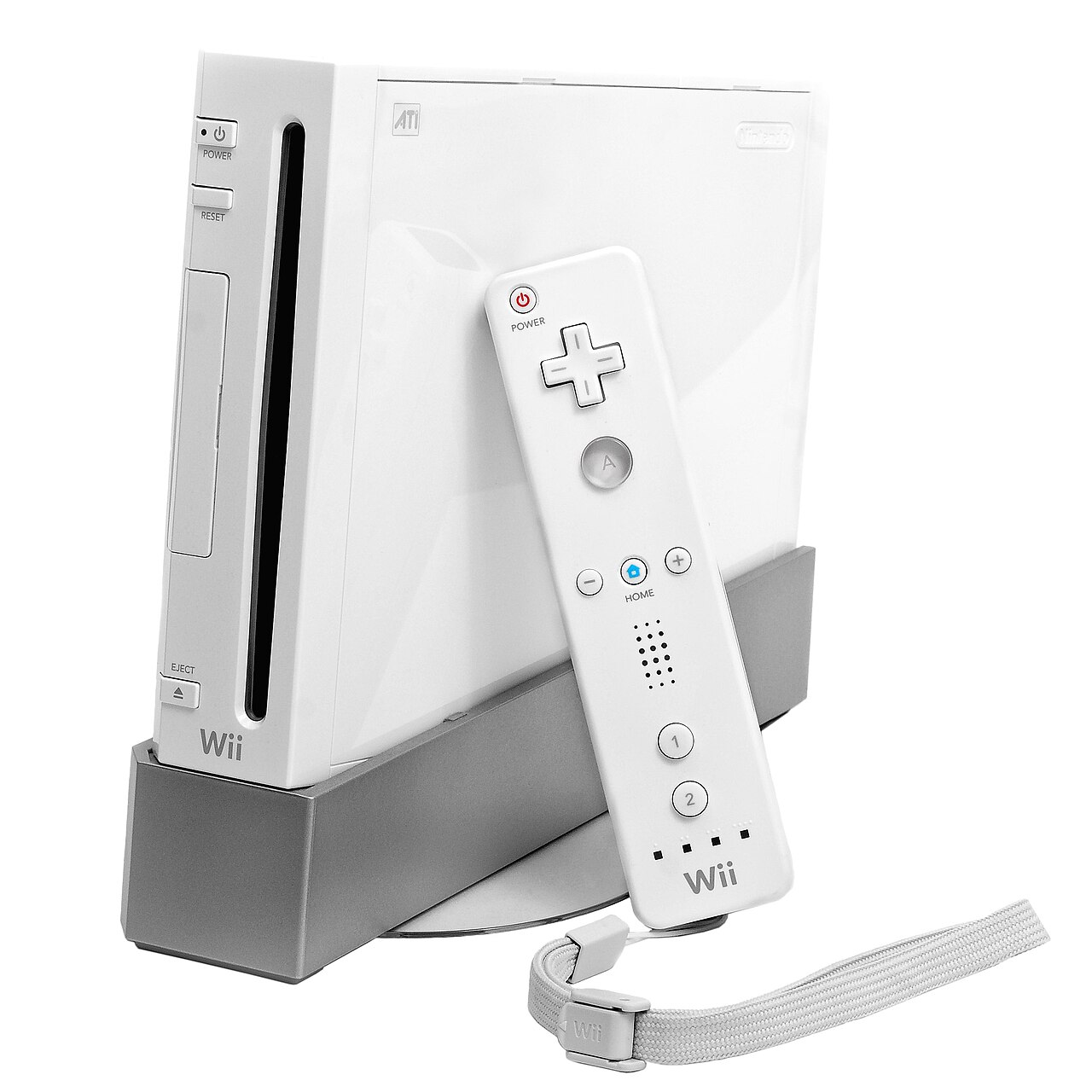 Glossy white games console standing upright on a grey base, with a white handheld controller and wrist strap in front of it, on white.