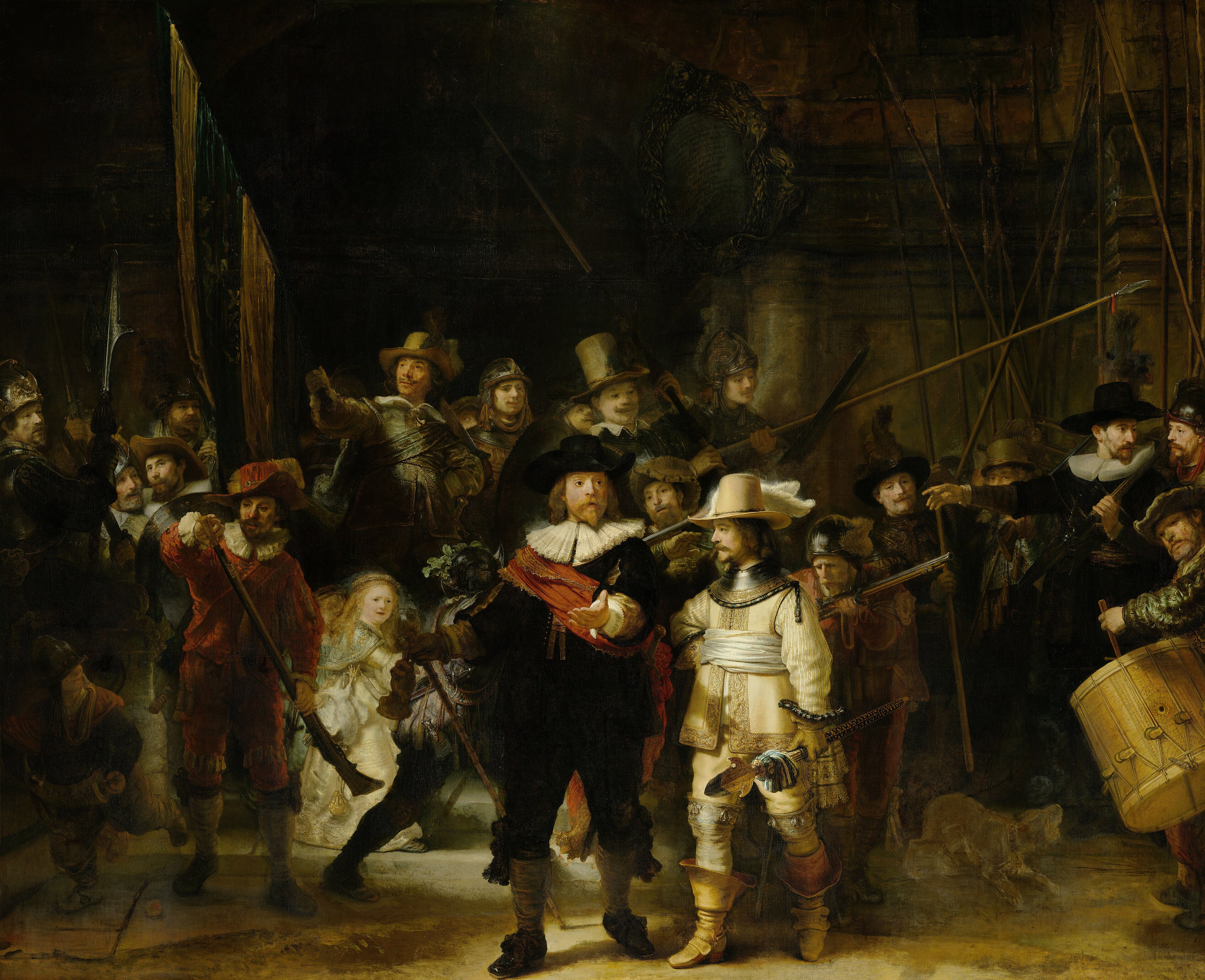 A large group of figures crowded in a dark hall, lit unevenly; some faces catch the light while others fall away.