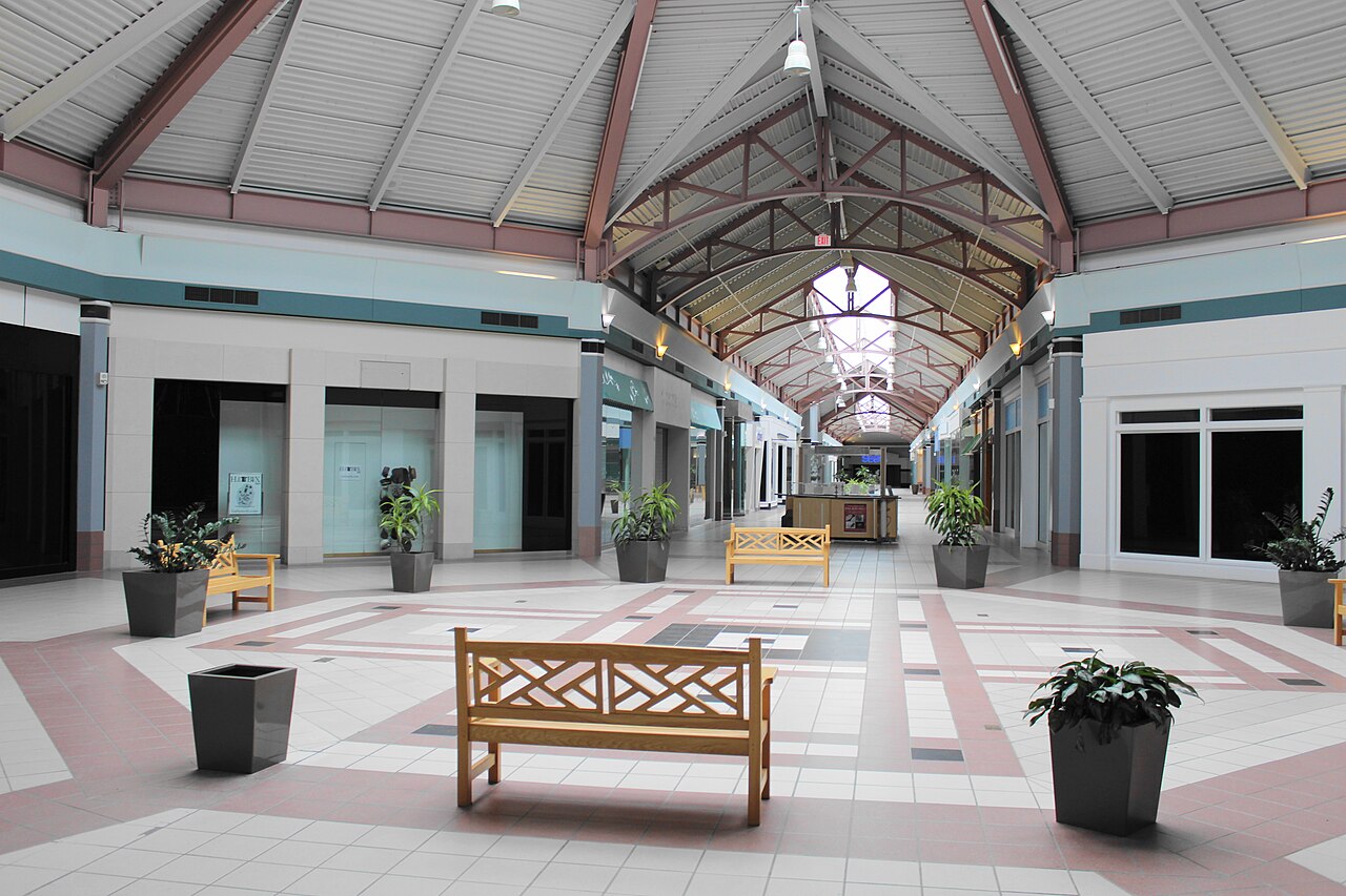 Empty central atrium of an American shopping mall, skylights and tiled floor, nobody in it