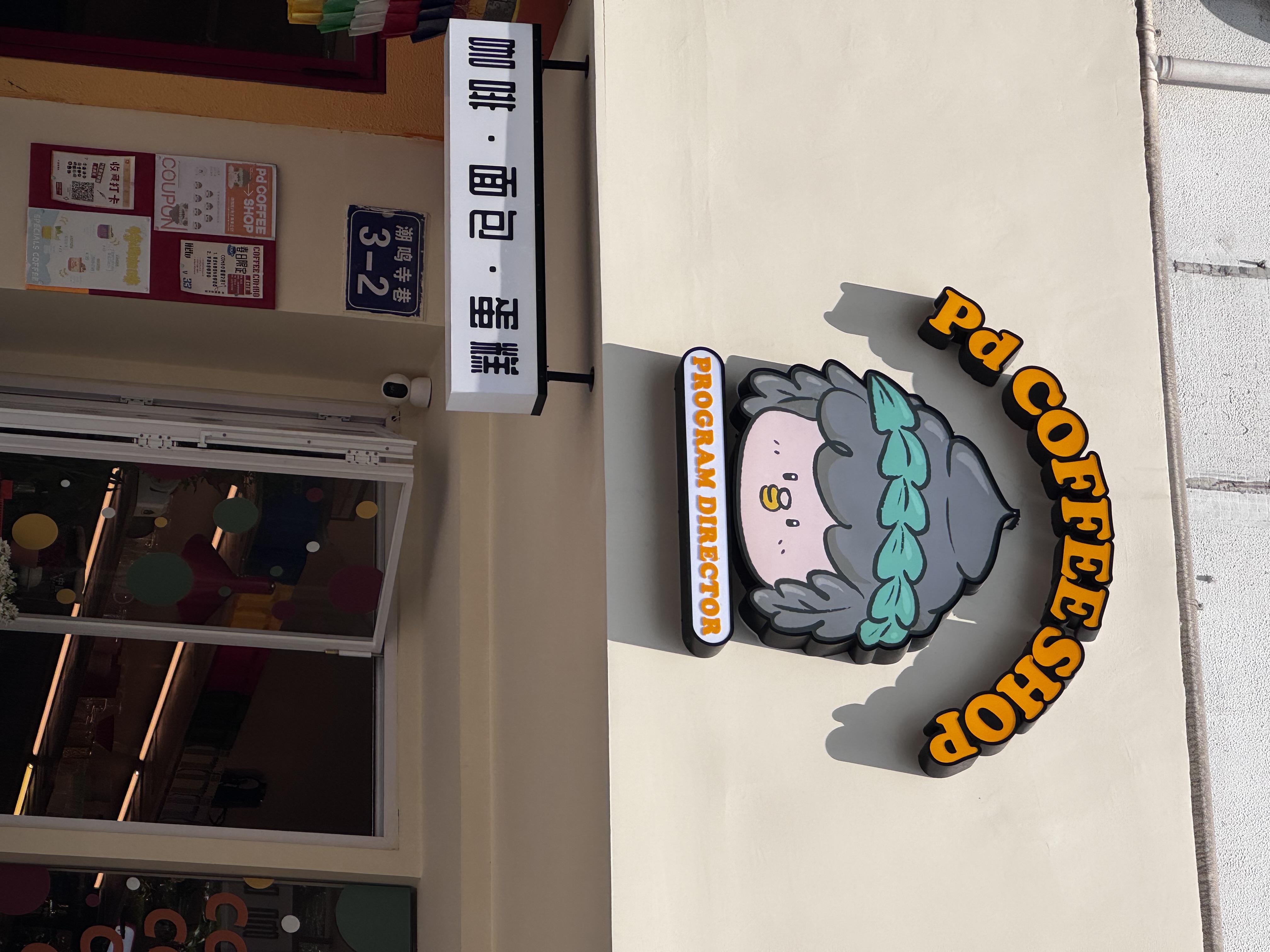 弄堂门口上方的 Pd COFFEE SHOP 招牌