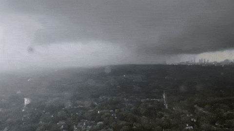 The city almost erased by rain, only a faint skyline visible at the right edge