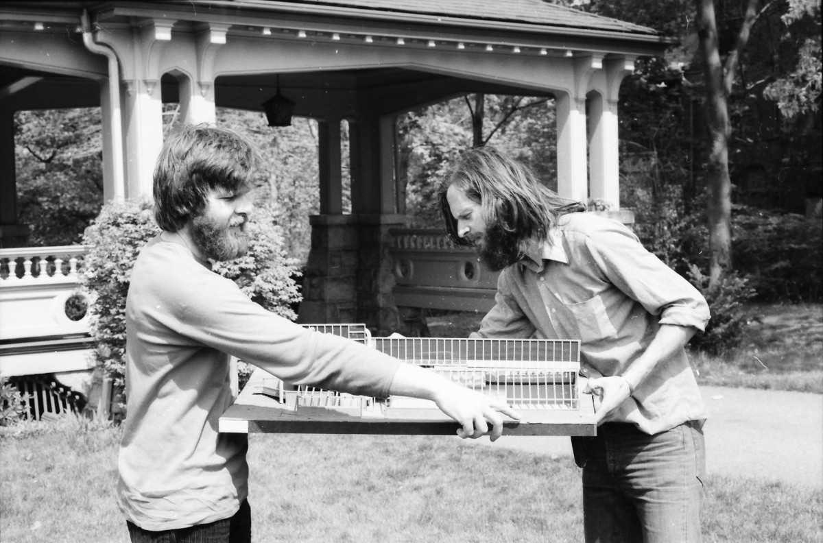 David Bergmark and Ole Hammarlund outdoors, together examining and holding the physical systems model of the PEI Ark.