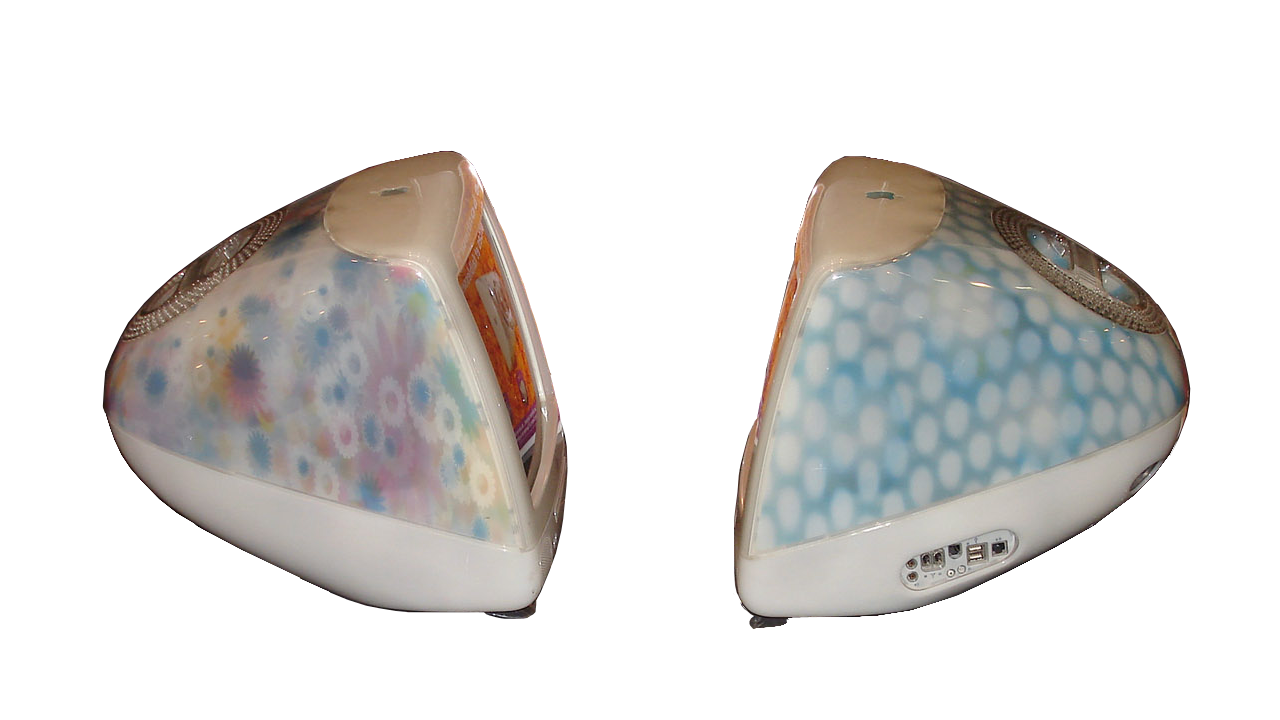 Two rounded iMac G3 all-in-one computers seen from behind, one with floral print, one with blue dalmatian spots