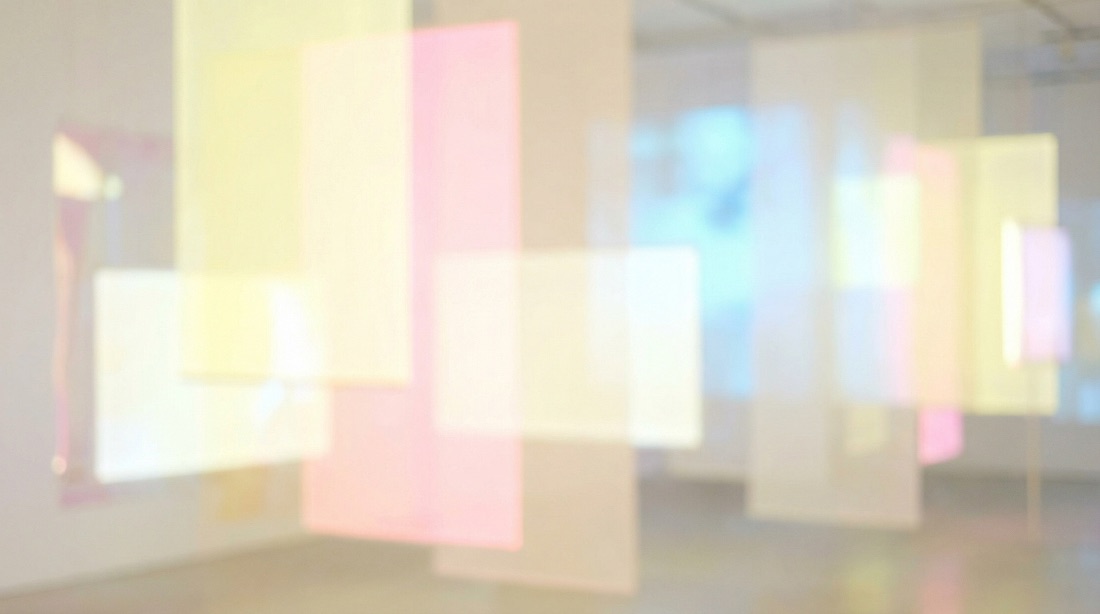 Blurred translucent color panels hanging in a gallery, lit by daylight