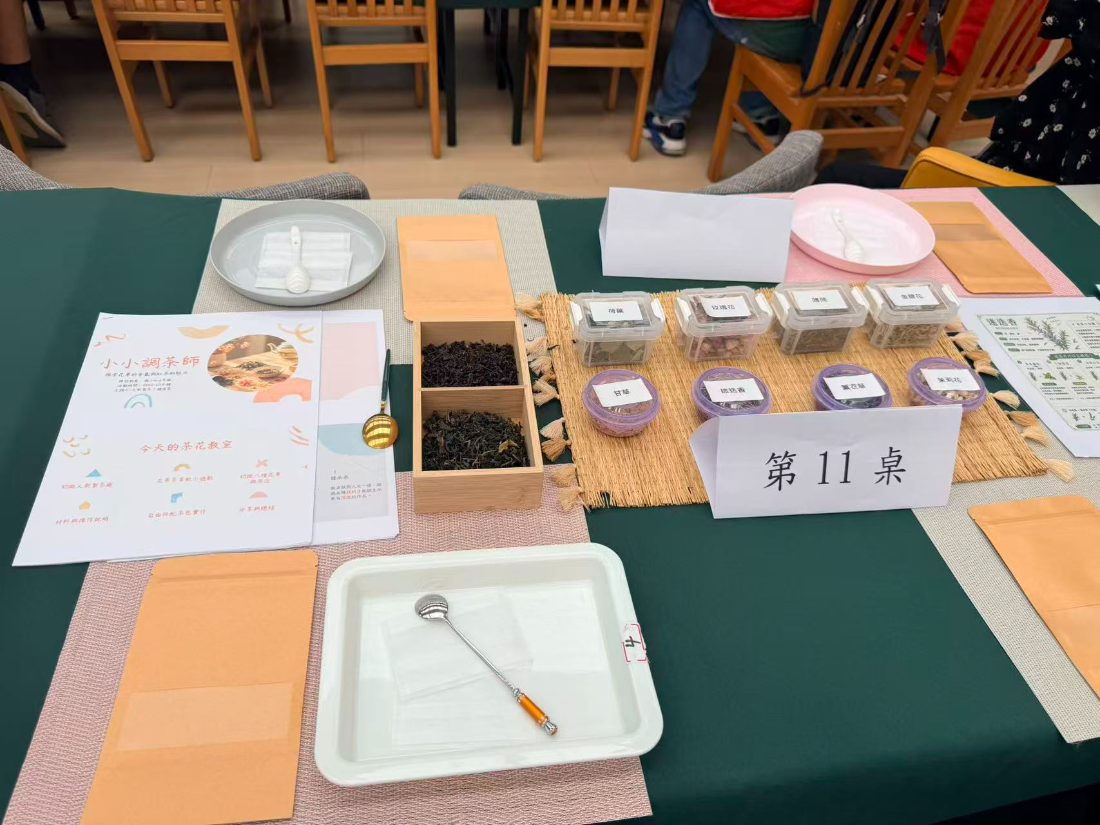Table 11's tea blending kit: worksheet, two kinds of tea leaf, small pots of dried flowers and a spoon