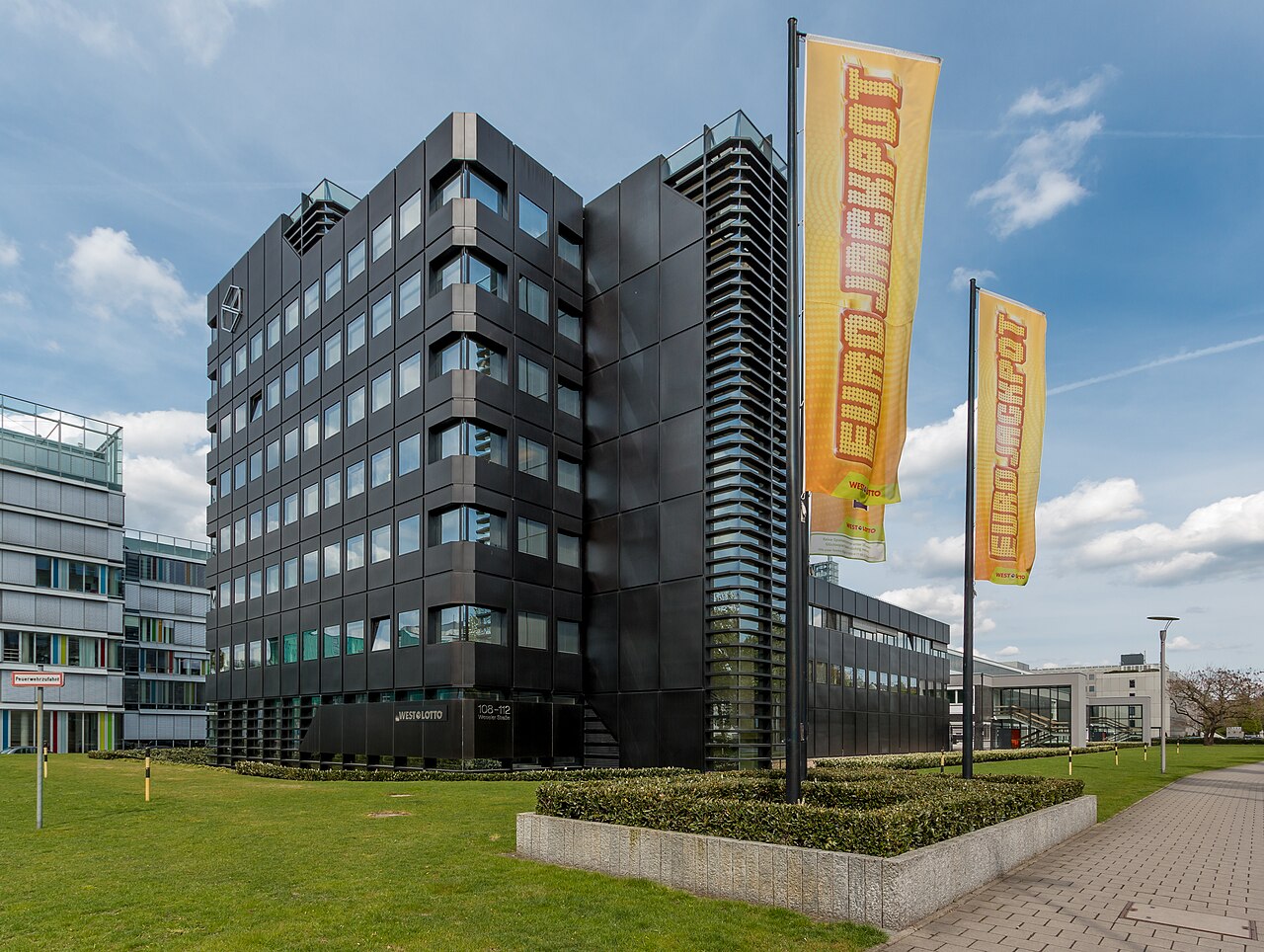 Glass office building, its facade reflecting sky and cloud.